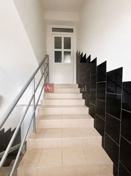 A staircase in a 3-room apartment with dark walls and railing.