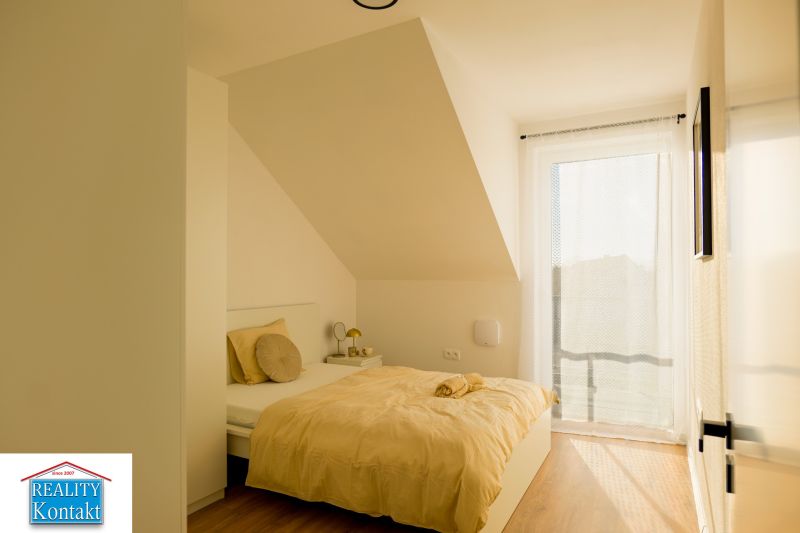 A bedroom in a family house with a wooden decor floor and soft beige tones.