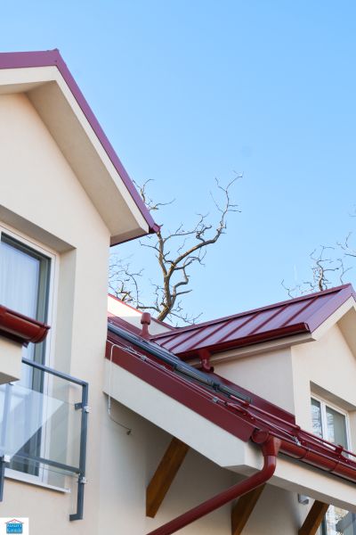 A part of the roof and balcony of a family house in Andovce with red details.