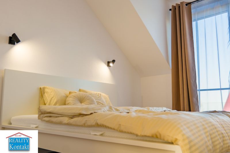 A bedroom in a family house with attractive lighting and a comfortable bed.