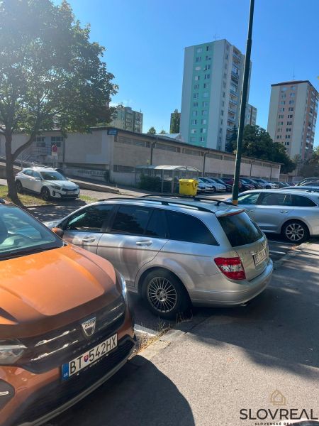 Parking lot on Púpavova Street, Karlova Ves district, with high-rise buildings.