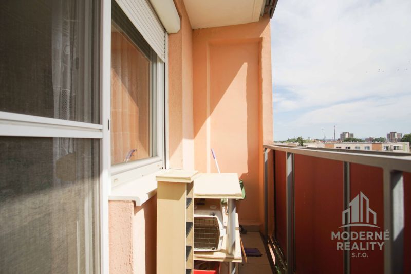 The balcony of a 4-room apartment in Nové Zámky with a view of the city and concrete panels.