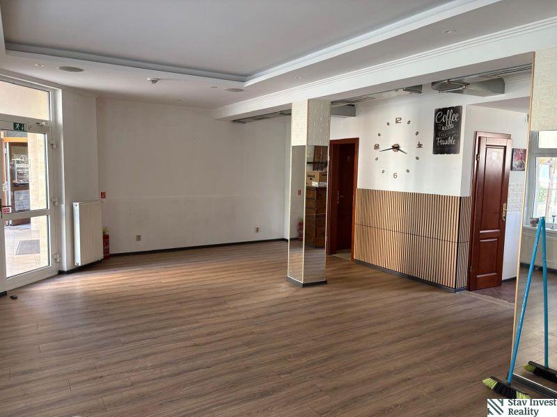Commercial space with a wood-patterned floor and decorative clock on the wall.