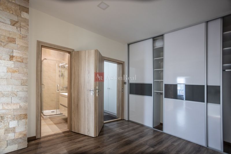 Interior of a 2-room apartment with a wooden decor floor and entrance to the bathroom.