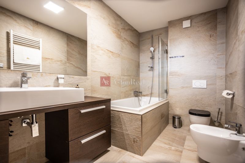 Luxury bathroom in a 2-room apartment with a large mirror and a bathtub.