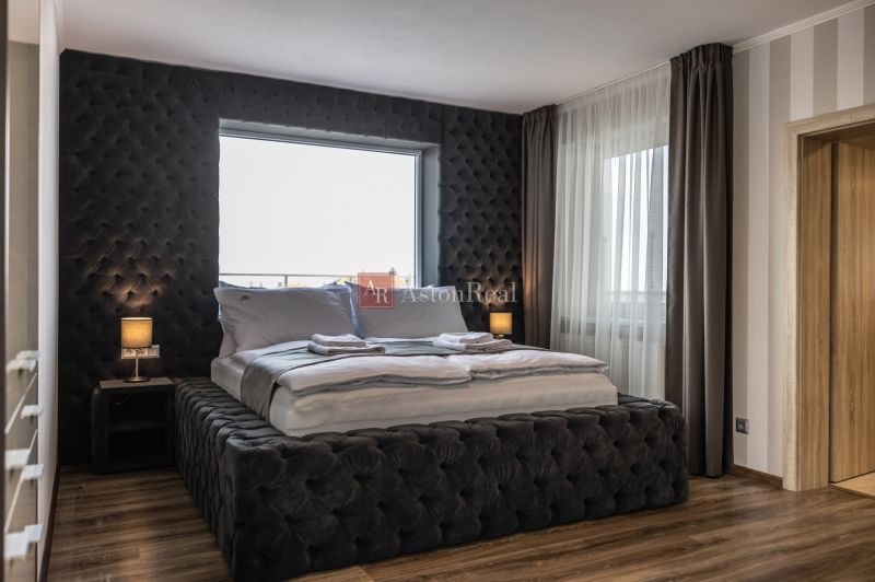 Bedroom in a 2-room apartment with a bed and a wooden decor floor.