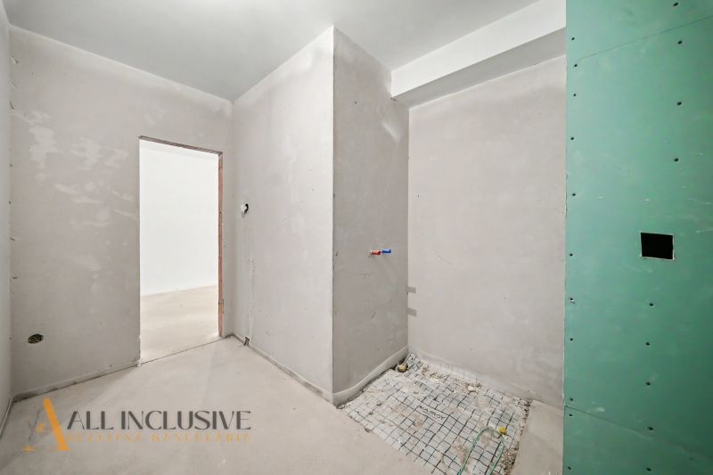 Bare walls in an unfinished 2-room apartment without completed flooring and doors.