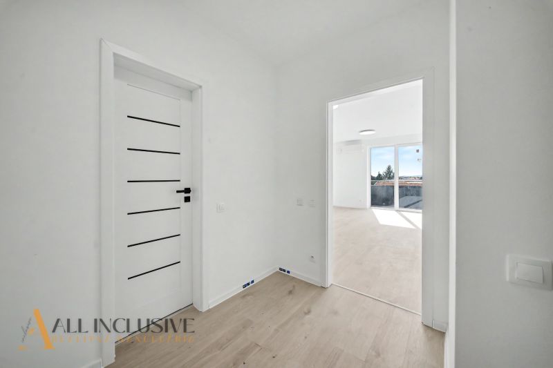 Interior of a 2-room apartment with a wooden decor floor and white doors.