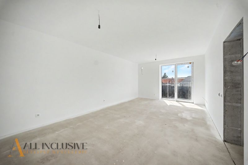 A spacious room in a 2-room apartment with large windows and a wooden decor floor.