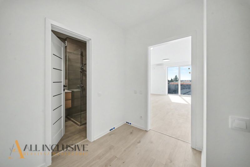 View from the hallway into the room with light and bathroom in a 2-room apartment.