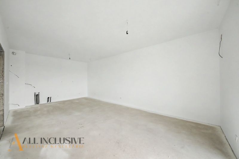 Empty room in a 2-room apartment with white walls and a concrete floor.