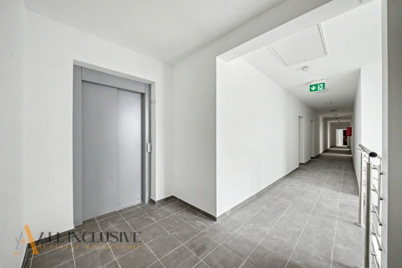 Hallway with an elevator and tiles in a 2-room apartment.