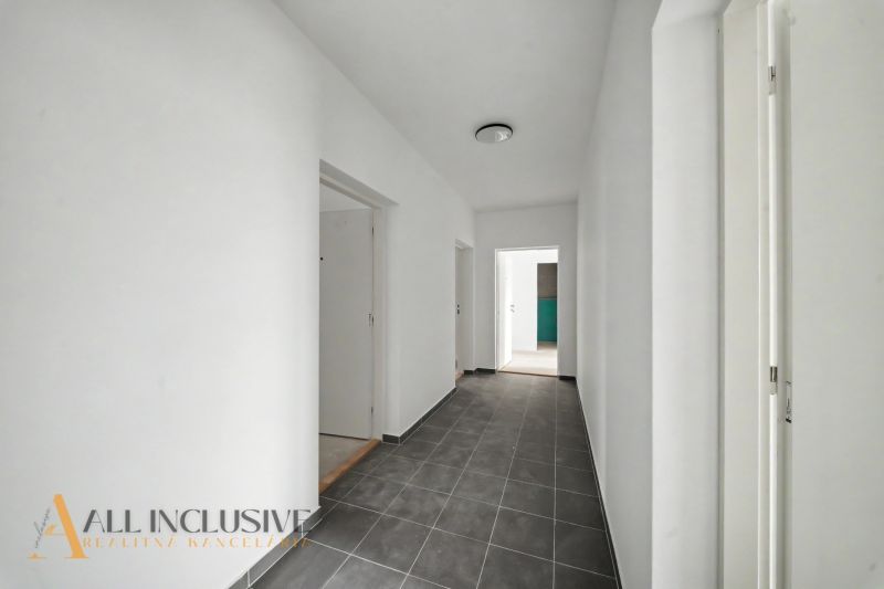 A bright hallway in a 2-room apartment with gray tiles and white walls.