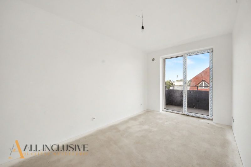 Empty room in a 2-room apartment, white wall, large window to the balcony.