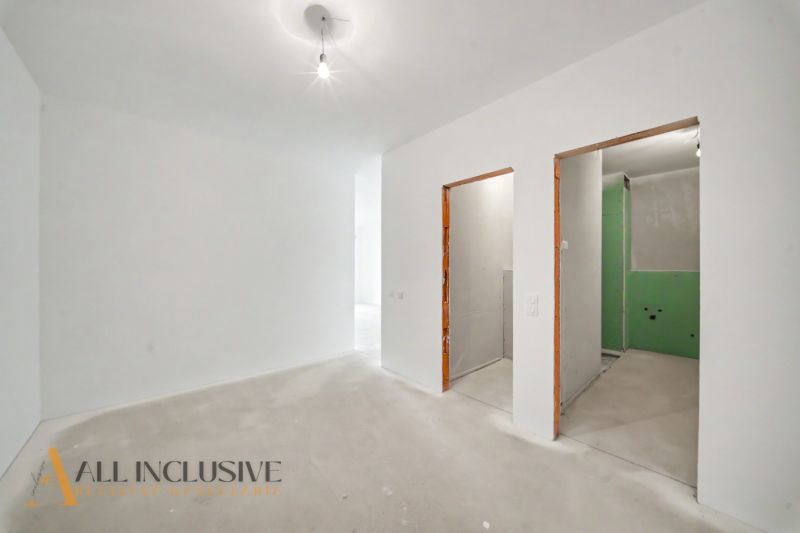 Interior of a 2-room apartment with bare walls and raw flooring.