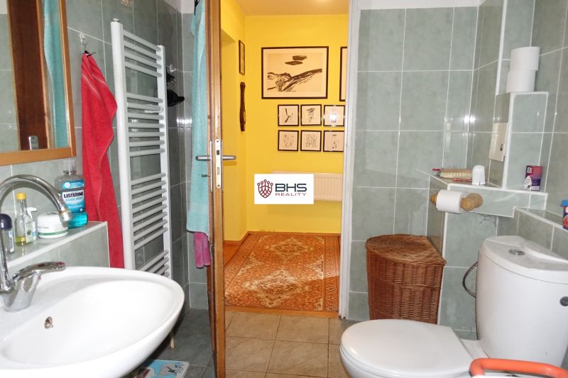 Bathroom in a family house with a sink, towels, and wall decoration.