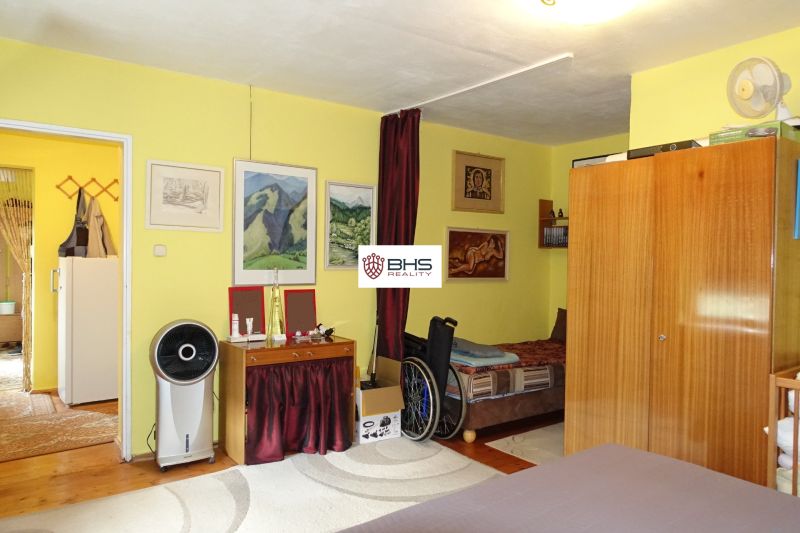 Bedroom of a family house with furniture, wall decorations, and a wooden decor floor.