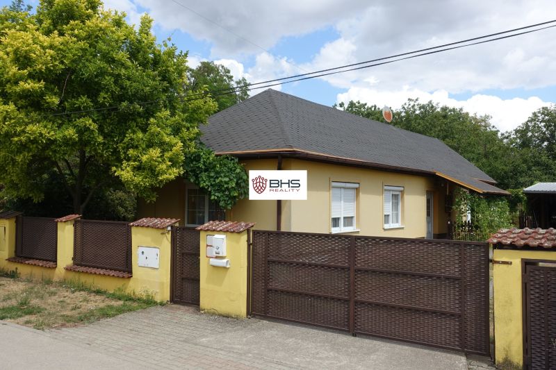 A family house in Mojmírovce on Tretí rad street, with a subtly coordinated fence and greenery.