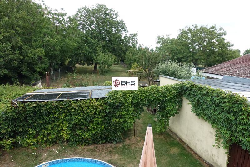 The garden behind the family house on Tretí rad Street in the village of Mojmírovce with a pool and greenery.