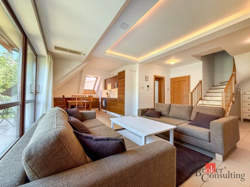 Living room with a sofa, dining table, staircase, wooden decor flooring in a 5 or more room apartment.