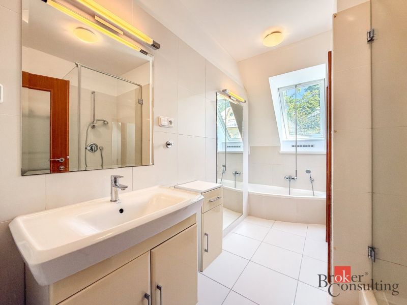 A bathroom in a 5 or more room apartment with a bathtub, shower, and large window.