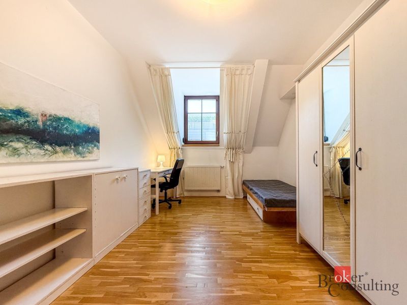 A room with a wooden floor decor, a writing desk, and a wardrobe in a five or more room apartment.