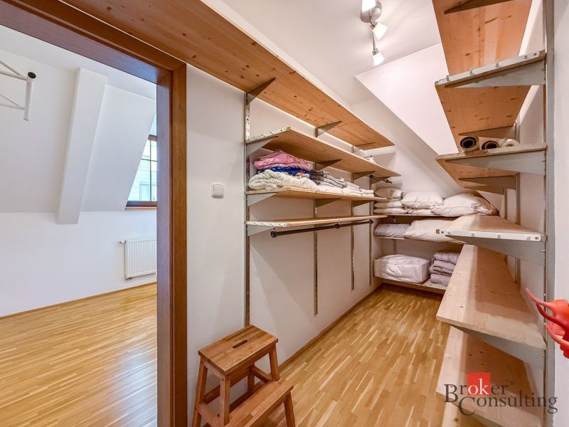 A wardrobe with shelves in a 5 or more room apartment, floor with wood decor.