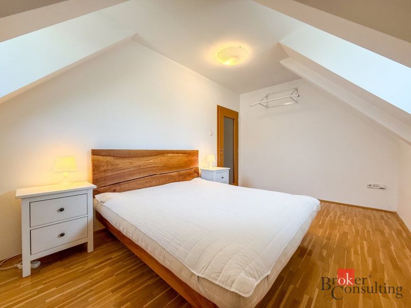 A bedroom with a wood-patterned floor and simple furniture in a 5 or more room apartment.