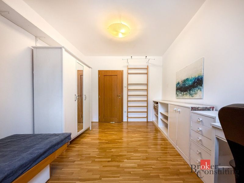 A room with a wooden decor floor, fully furnished, in a 5 or more bedroom apartment.