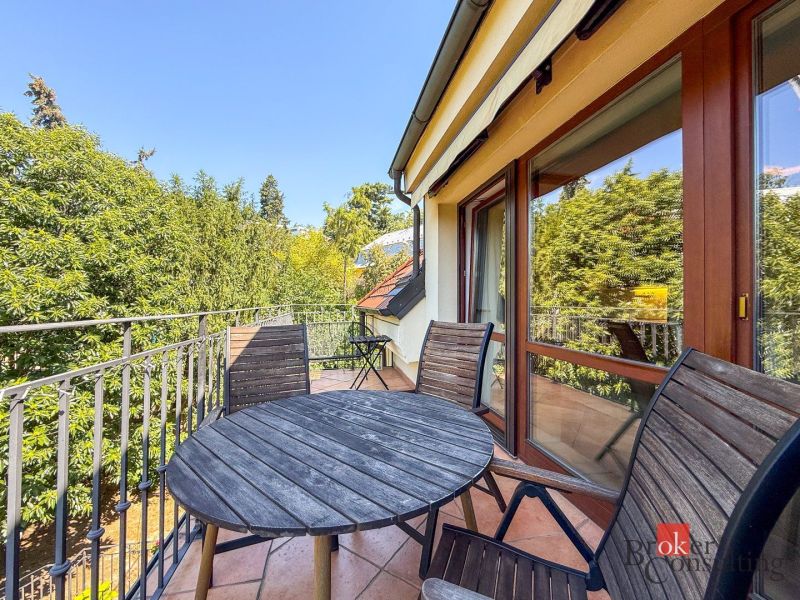 A terrace with wooden furniture, a view of greenery, access from a 5 or more room apartment.