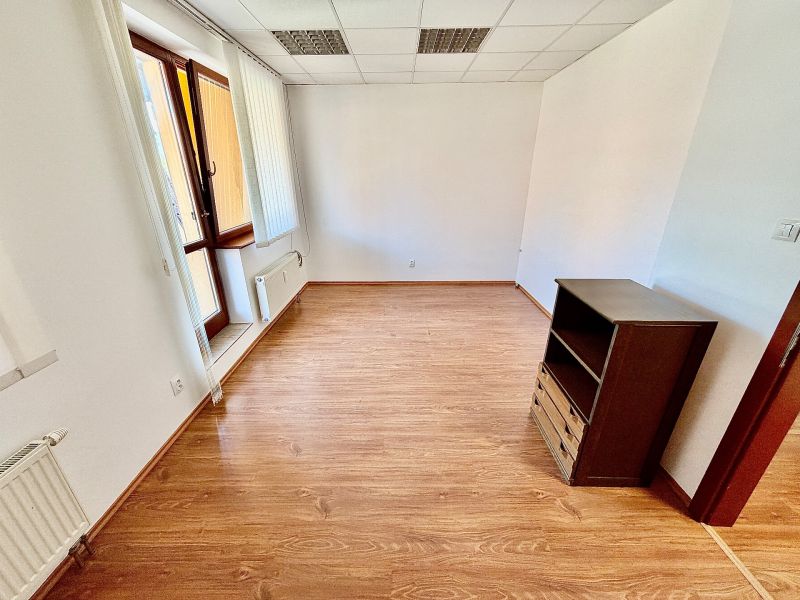 Offices with wood-patterned flooring, illuminated by a large window, and storage space.