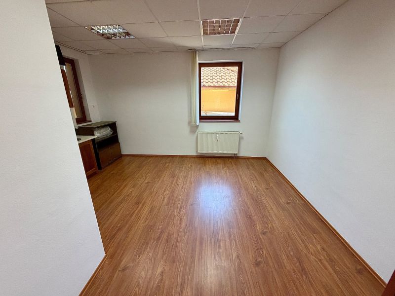Offices with wood-patterned flooring, white walls, and a small window.