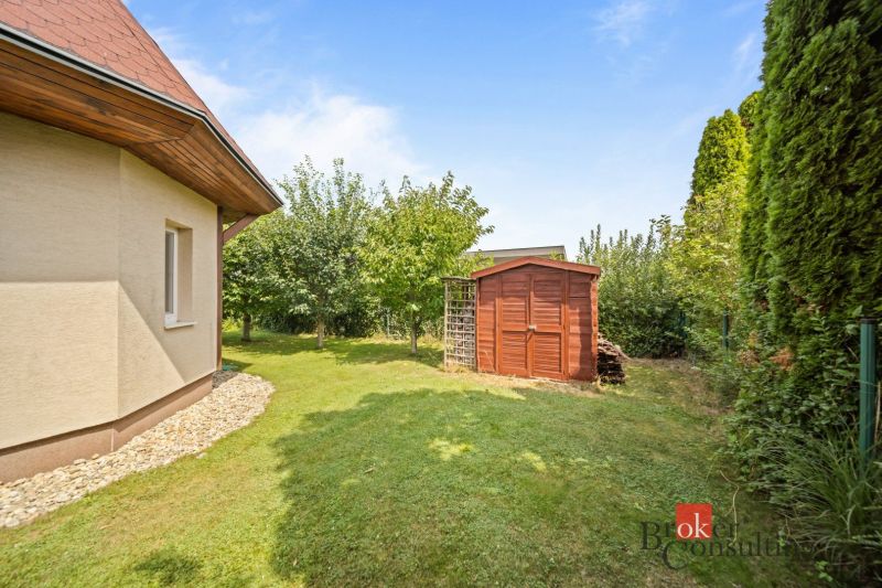 Wooden shelter and grassy garden by the cottage in Vojka nad Dunajom.