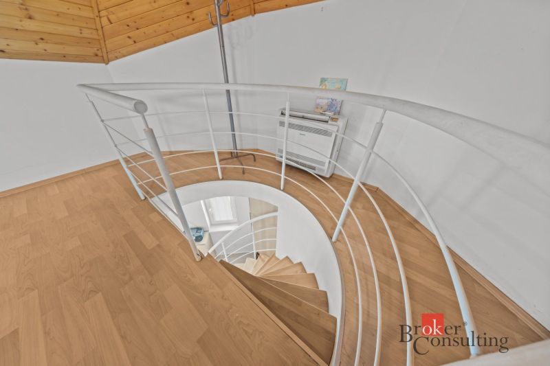 A spiral staircase and a wooden-decor floor in a cabin.