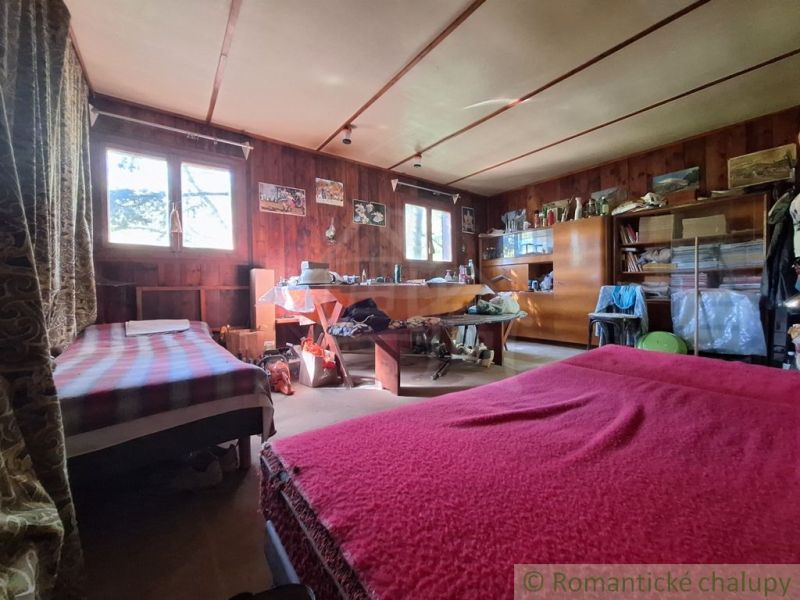 A spacious room in a cabin with two beds, wooden decor, and storage spaces.