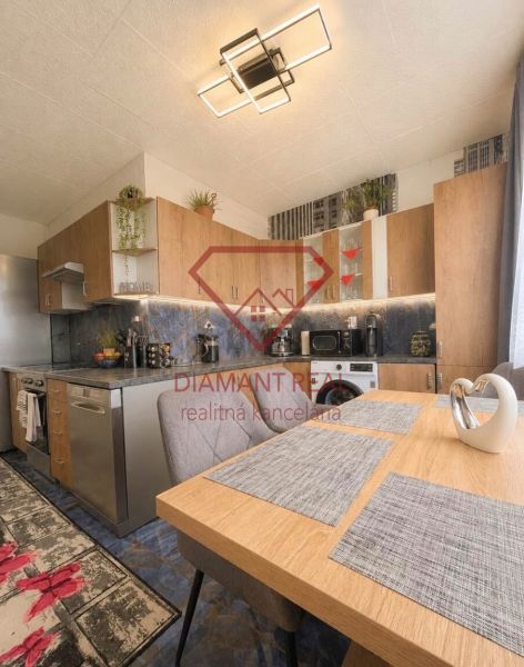 Kitchen in a 2-room apartment with furnishings, wooden decor, and modern lighting.