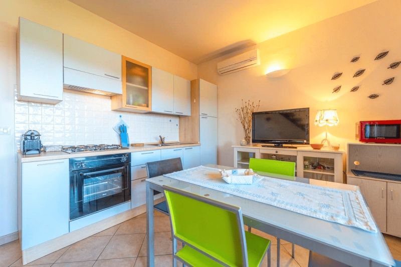 A kitchen in a holiday apartment with a dining table and modern appliances.