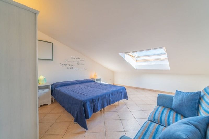 A bright bedroom in a holiday apartment with a double bed and a skylight.