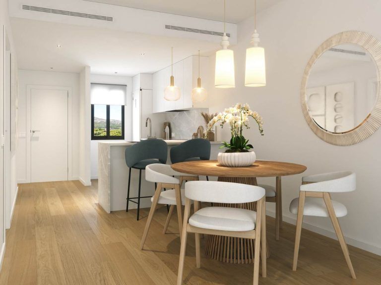 Dining area with a round table and wood-patterned flooring in a 3-room apartment.