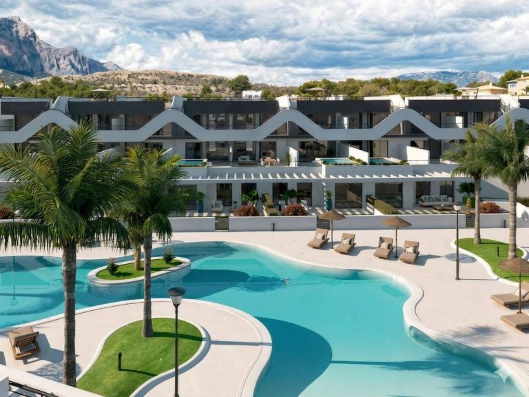 Residential building in Costa Blanca with a pool and palm trees, suitable for a 3-bedroom apartment.