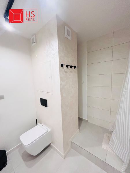 Bathroom in a 3-room apartment with a toilet and shower, fresh white tones.