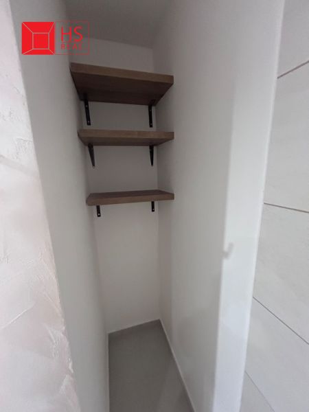 A narrow corner with three shelves in a 3-room apartment.