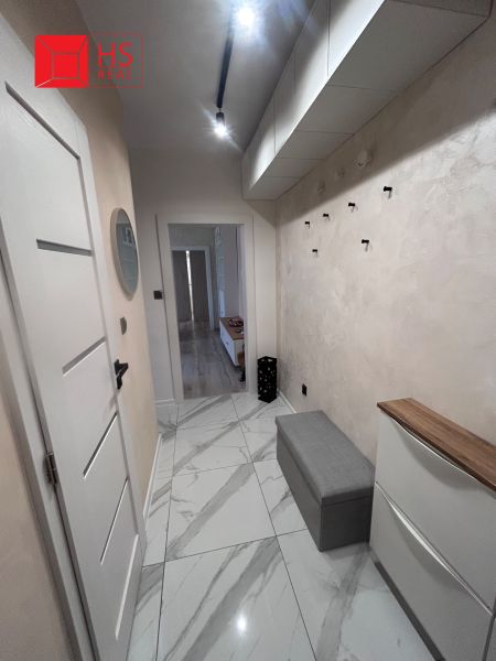A hallway in a 3-room apartment with ceramic tiles, storage space, and lighting.