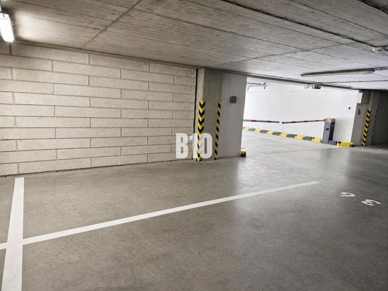 A parking lot in garages, clean concrete walls, and lighting complement the lines on the floor.