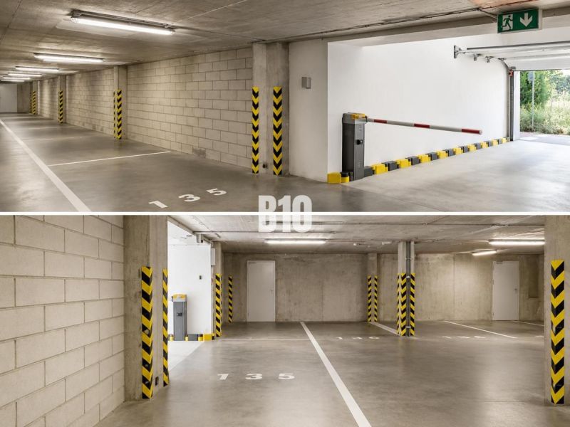 Underground parking in garages with numbered spaces and a barrier.