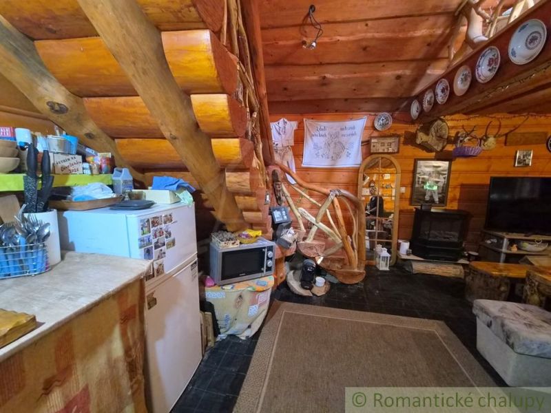 A wooden interior of a family house with rustic elements, wooden stairs, and a kitchen.