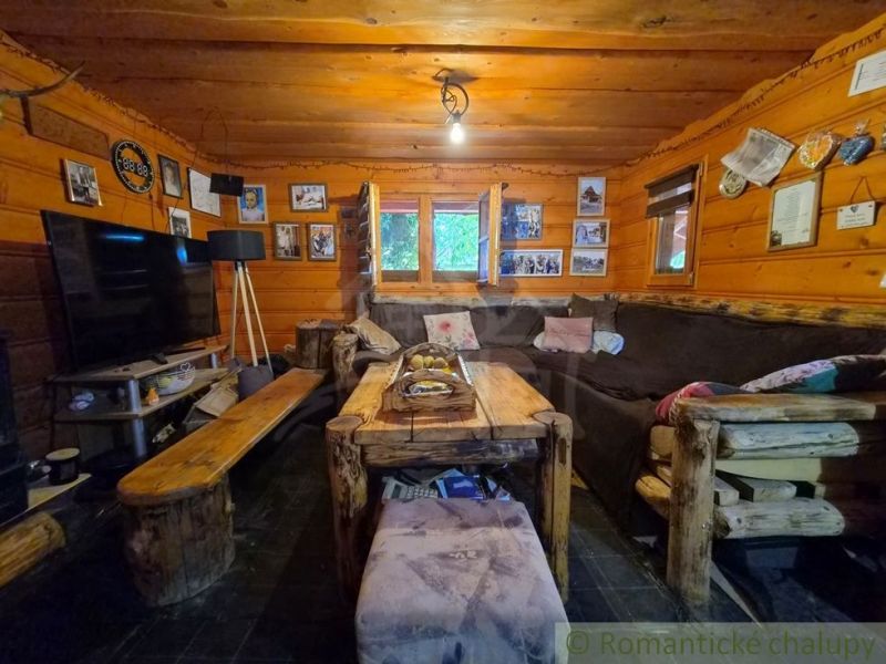 A rustic interior of a living room in a family house with wooden ceilings and furniture.