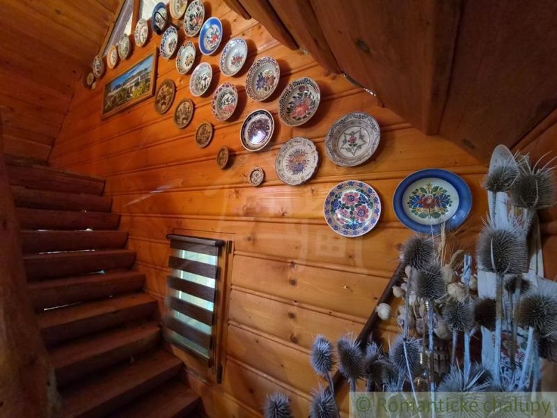 Wooden interior with decorative plates on the wall, staircase, decorations.