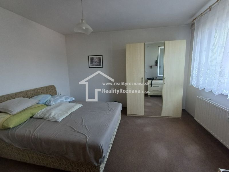 A bedroom in a 3-room apartment with a bed, a wardrobe, and a picture on the wall.