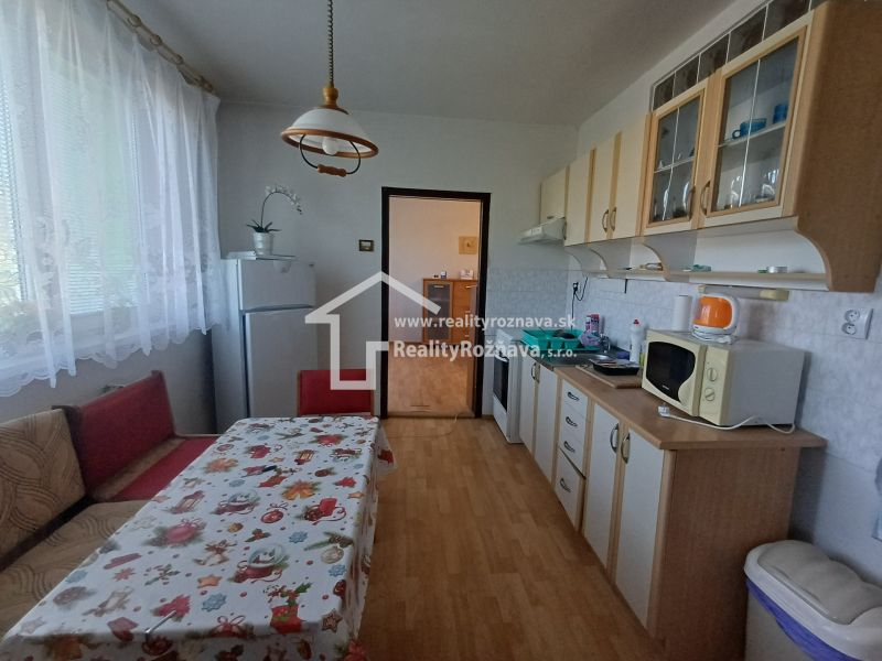 A kitchen in a 3-room apartment with a dining area and a wooden decor floor.